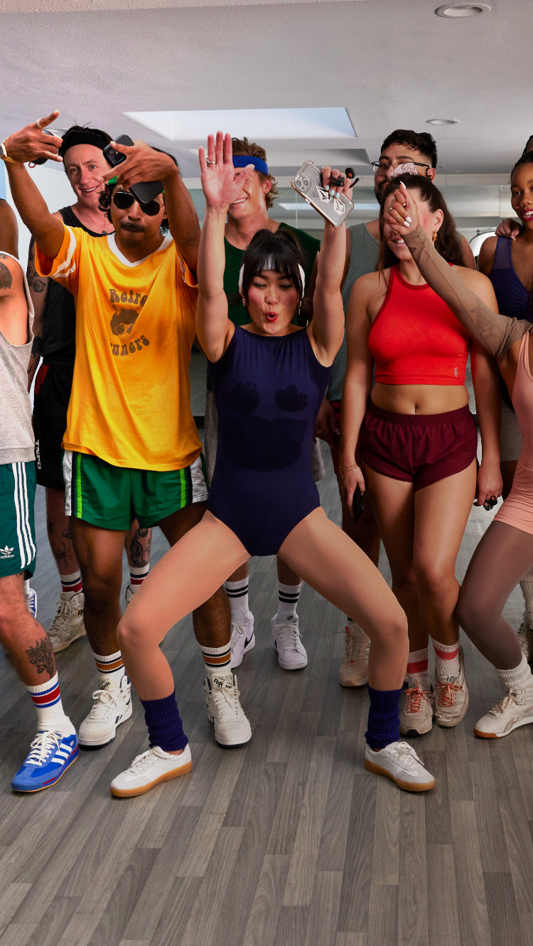 Group of young men and women posing after a work out class while wearing active sport earbuds.