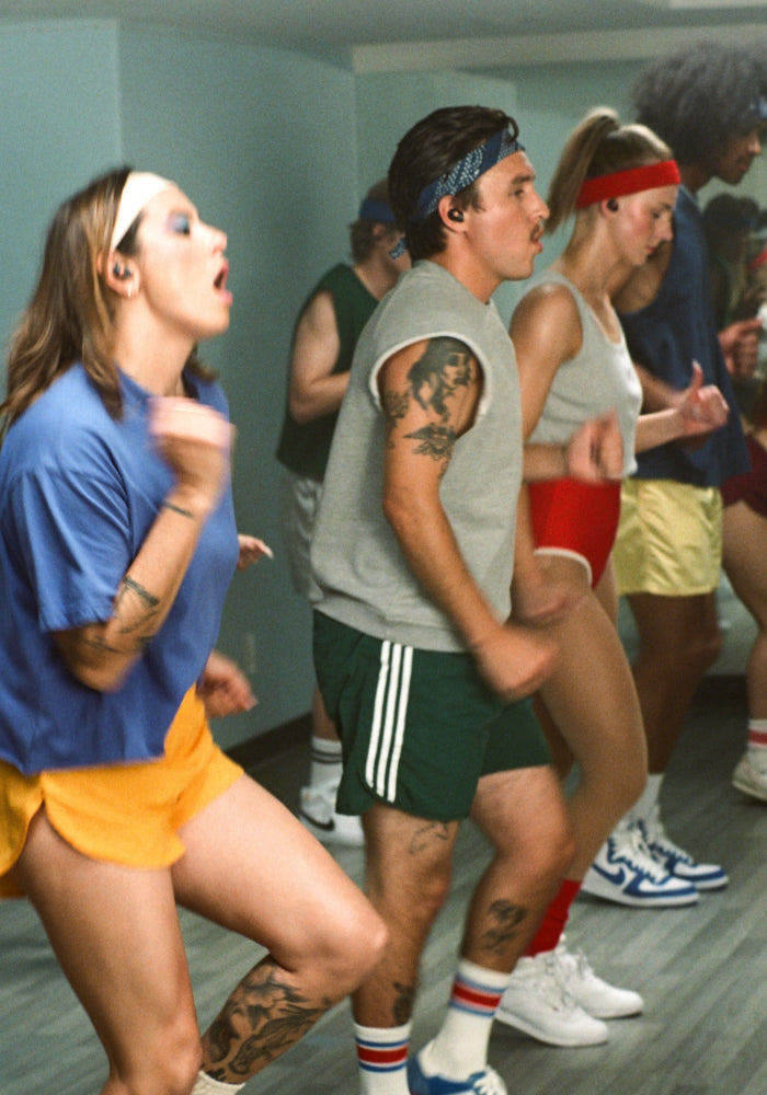 Exercise class running in place while wearing Skullcandy wireless earbuds.